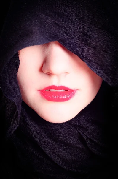 Parte do rosto de uma mulher com capuz preto — Fotografia de Stock