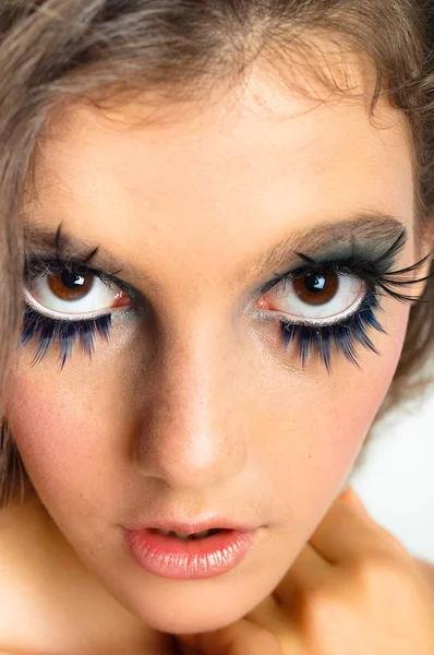 Young beautiful girl with extreme makeup on white isolated backg Stock Picture