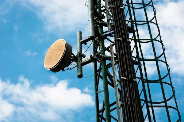 Komunikační věž proti modré obloze mraky — Stock fotografie