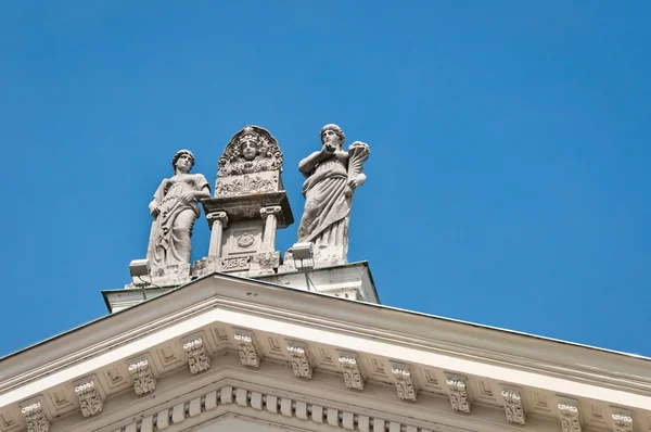 Estátuas romanas em um telhado contra o céu azul — Fotografia de Stock