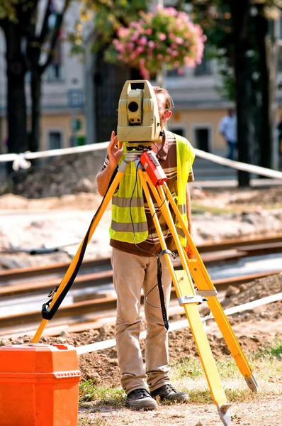 Werknemer inspectie site met zijn statief en industriële apparaat — Stockfoto