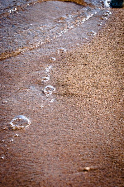 Burbujas y arena en la orilla de la playa —  Fotos de Stock
