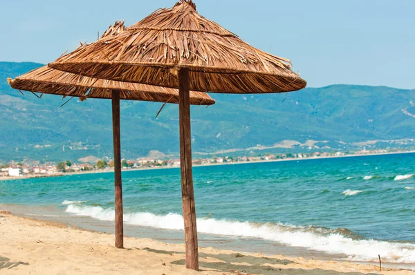 Umbrellas on the beach with mountan and ocean — Stock Photo, Image