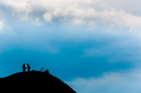 Un couple atteint le sommet de la montagne — Photo