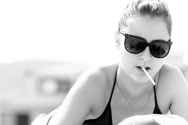 Mayo plajda sigara içmeye başlayan genç kadın — Stok fotoğraf