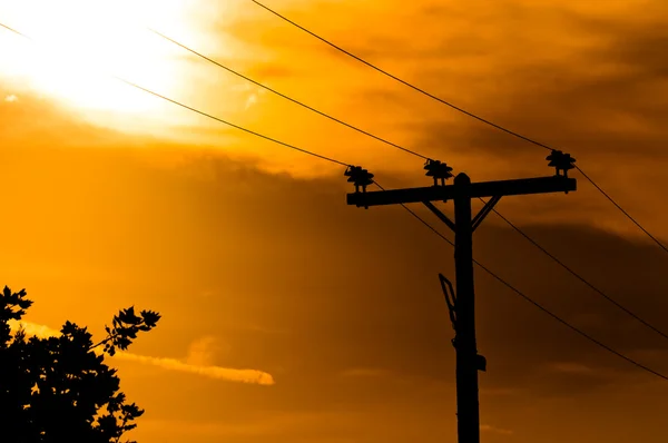 Poste de alto voltaje contra el cielo al atardecer — Foto de Stock