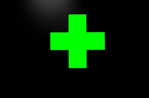 stock image Green cross on black background with a little light