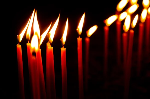 Czerwone świece w wierszu świecące — Zdjęcie stockowe
