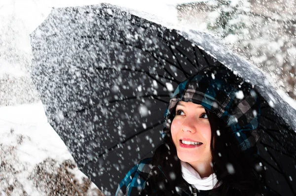 Jonge vrouw met paraplu in een sneeuwstorm — Stockfoto