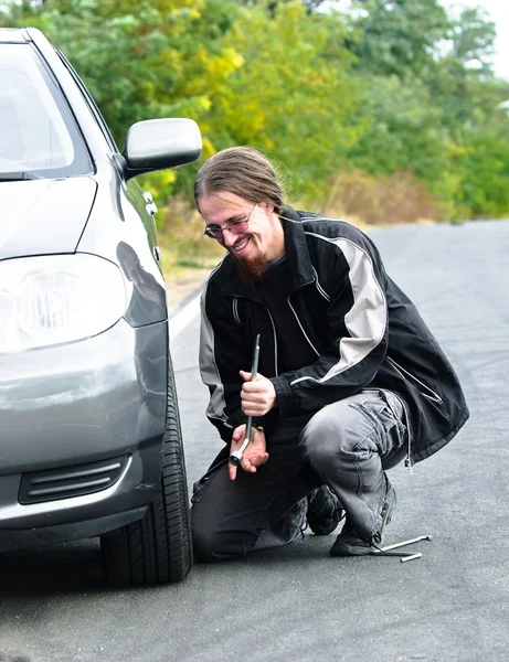 Красивый молодой человек ремонтирует машину. — стоковое фото