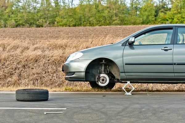 Coche sin neumático en la carretera —  Fotos de Stock