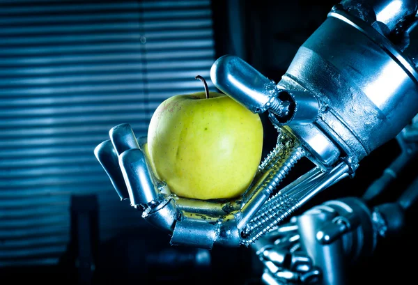 Una mano robot che tiene una mela fresca — Foto Stock