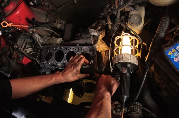 Händerna på en arbetstagare reparera bilen — Stockfoto