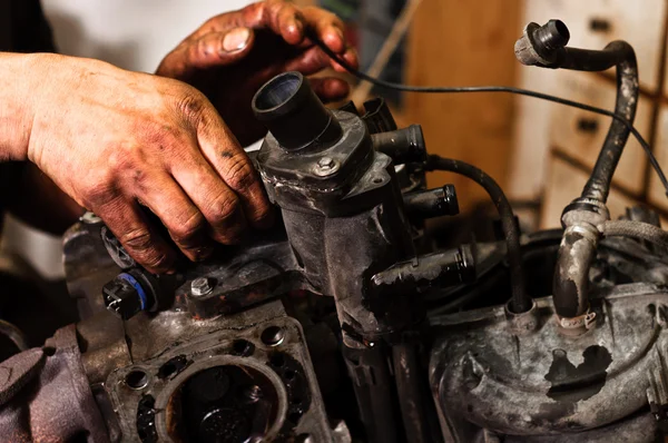 Mani di un lavoratore che ripara un motore rotto — Foto Stock