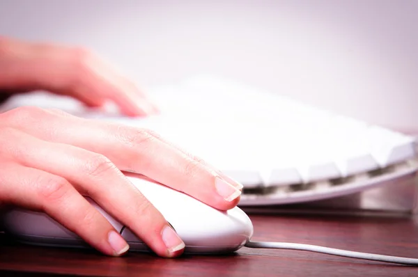 Mãos de uma mulher usando mouse e teclado — Fotografia de Stock