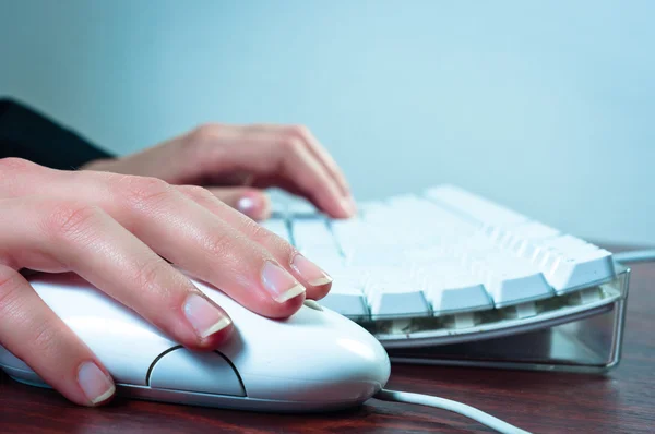 Mãos de uma mulher usando mouse e teclado — Fotografia de Stock