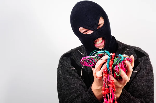 Thief in mask holding expensive goods — Stock Photo, Image