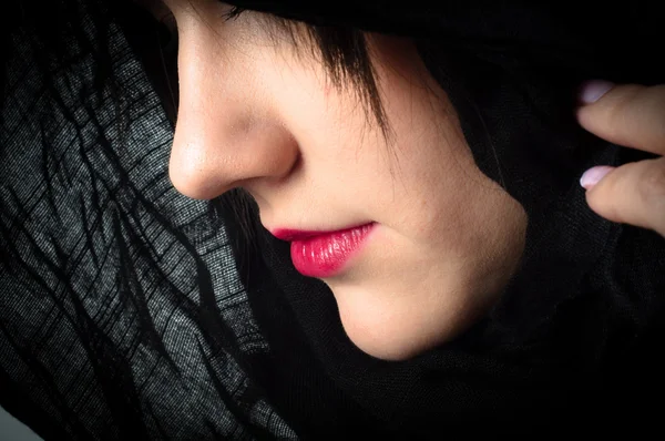Closeup φωτογραφία μιας γυναίκας με μαύρη κουκούλα και κόκκινα χείλη — Φωτογραφία Αρχείου