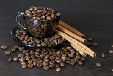 koyu arka plan üzerine bir fincan kahve çekirdekleri