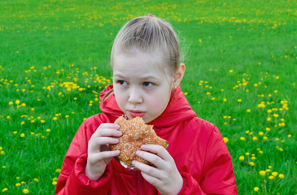 Frightened beautuful girl eating hamburger.