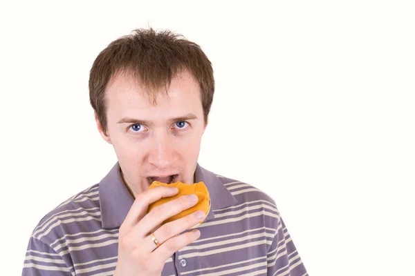 stock image The young man is appetizing eats a hamburger.