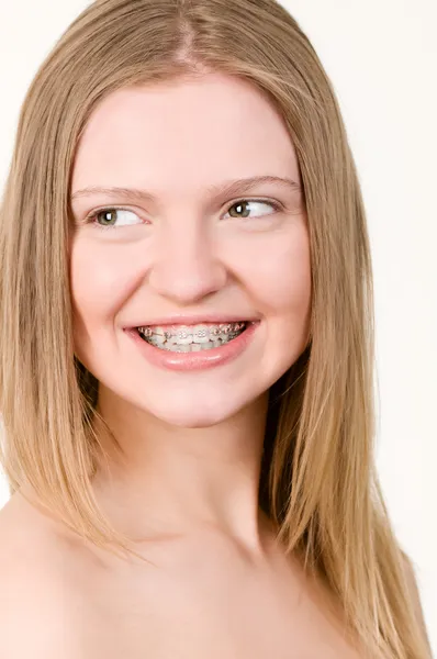Szép, fiatal lány, a zárójelben a fogak — Stock Fotó