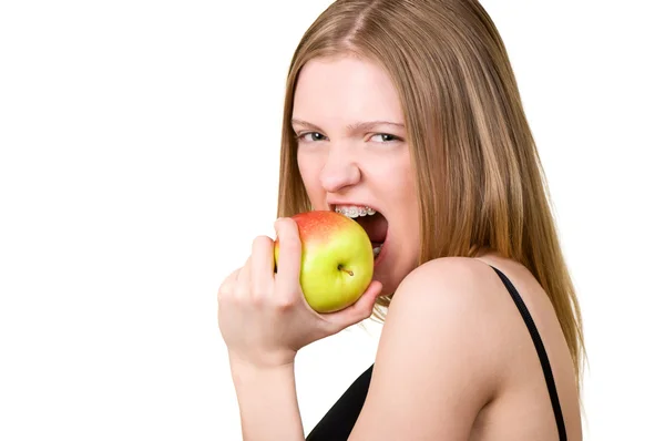 Όμορφη νεαρή γυναίκα με αγκύλες στα δόντια που τρώει το μήλο — Φωτογραφία Αρχείου
