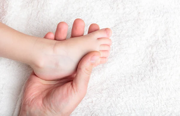 Babası yavaşça bebeğin bacak tutun — Stok fotoğraf