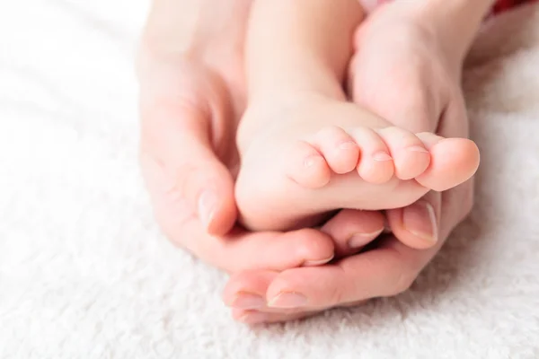 Annesi yavaşça bebeğin bacak tutun — Stok fotoğraf
