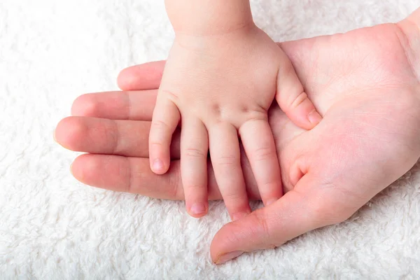 Mors hand hålla barnets hand — Stockfoto