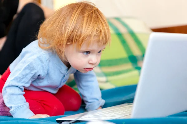 Pequena menina brilhante usando laptop — Fotografia de Stock