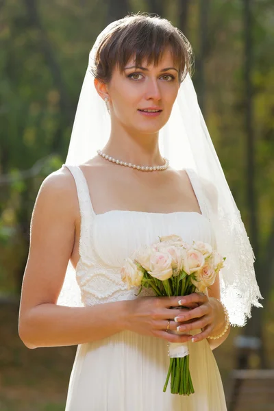 Schöne Braut mit Brautstrauß — Stockfoto