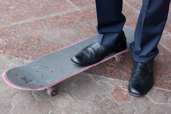 Geschäftsmann steht auf Skateboard — Stockfoto