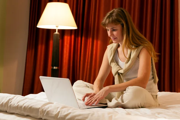 Młoda kobieta korzysta z laptopa w hotelu — Zdjęcie stockowe