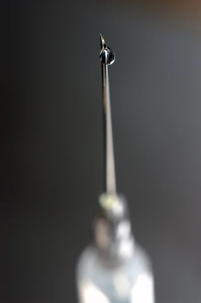 Syringe close-up, focus on the drop — Stock Photo, Image