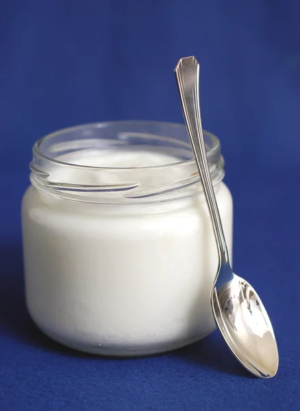 Yoghurt op blauwe achtergrond — Stockfoto