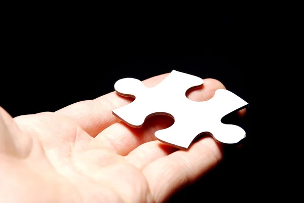 Mão segurando uma peça de puzzle — Fotografia de Stock