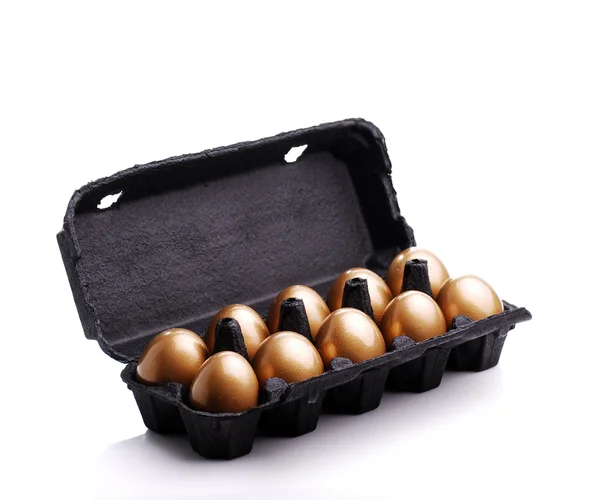 Złote jaja w kartonie czarne — Zdjęcie stockowe