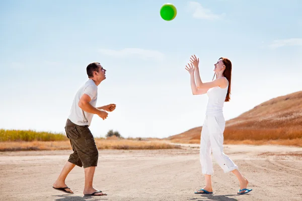 Happy couple playing with a ball — Stock Photo, Image