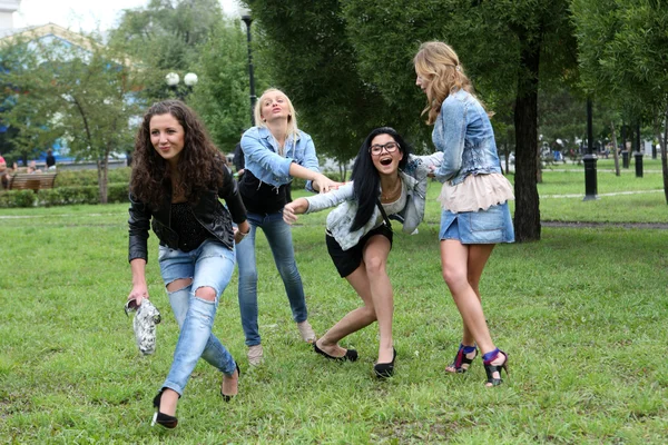 Glad fyra flickor i parken våren — Stockfoto