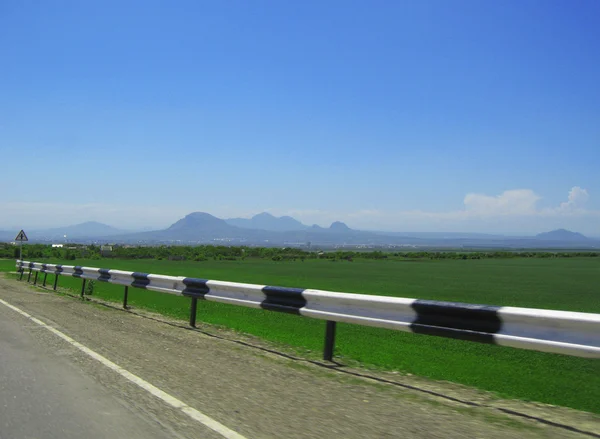 Estrada larga e montanha. Nuvens sobre e céu azul — Fotografia de Stock