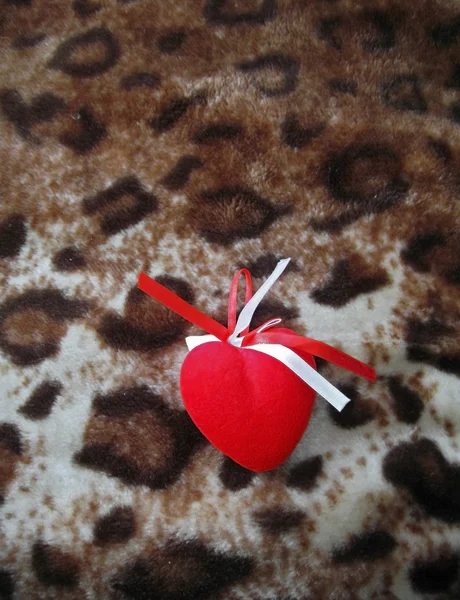 Czerwone serce z biało -czerwone paski na brązowym tle — Zdjęcie stockowe