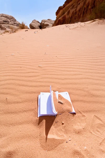Office notebook in rode zand van dessert — Stockfoto