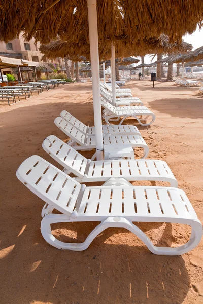 Plastic beach beds on coral bay — Stock Photo, Image