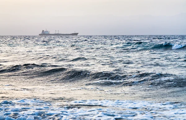 青の夕日に赤い海の乾燥した貨物船 — ストック写真
