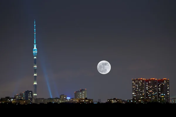 Volle maan onder stad — Stockfoto
