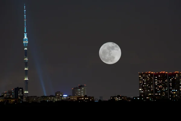 Volle maan onder stad — Stockfoto