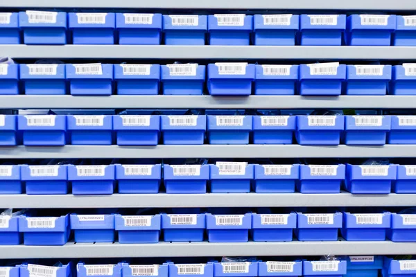 Blue plastic boxes in storage stand — Stock Photo, Image