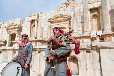 Bedouin plays on bagpipes in ancient town Gerasa in Jordan clipart