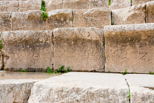 Números gregos antigos em assentos de pedra no antigo Grande Teatro Sul, Jerash — Fotografia de Stock